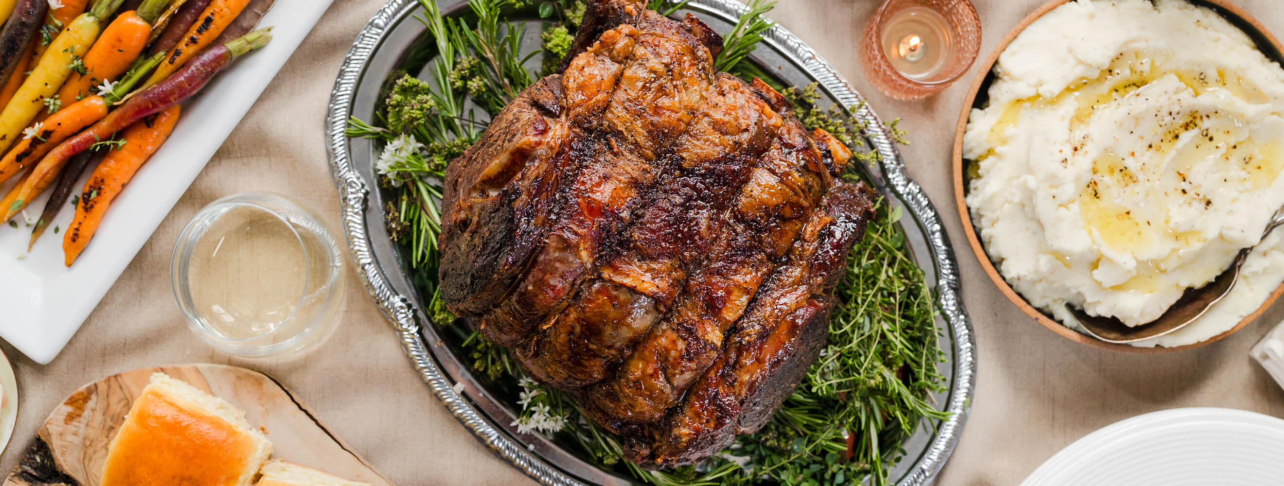 An oven-roasted turkey on a platter with a bowl of cranberry sauce on the side.