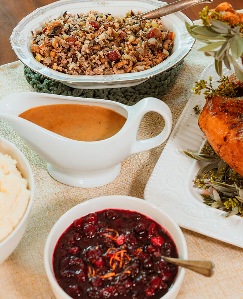 Holiday sides of mashed potatoes, cranberry sauce and stuffing on a table