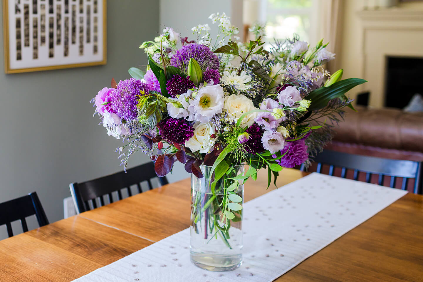 New Seasons hand-curated floral arrangement in a clear vase with purple and white flowers.