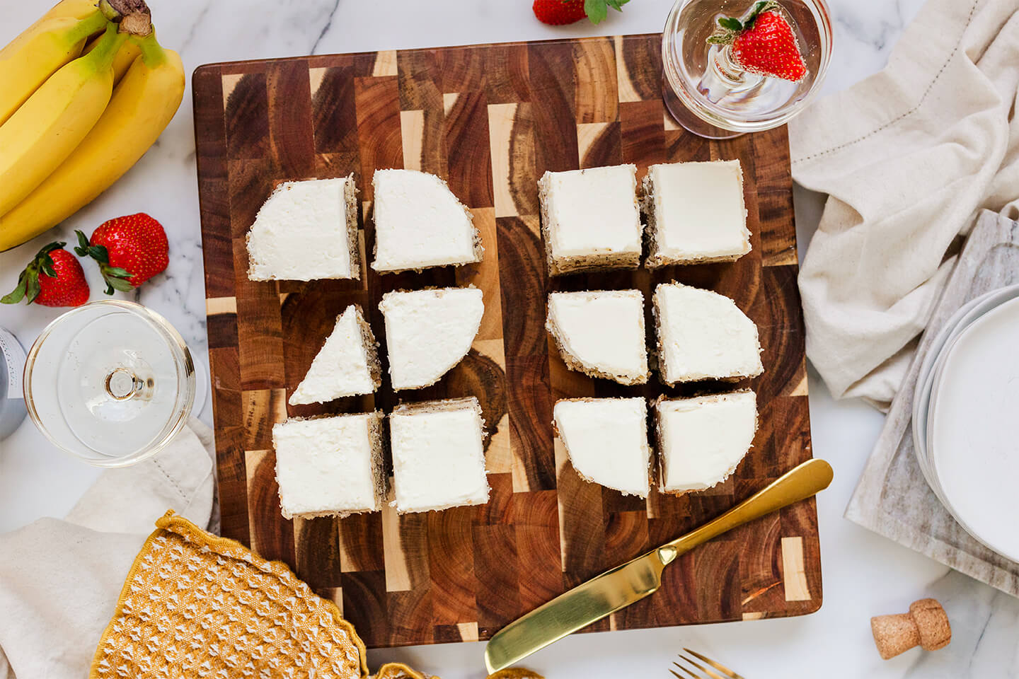 Slices of New Seasons’ banana cake served on plates with lit birthday candles.