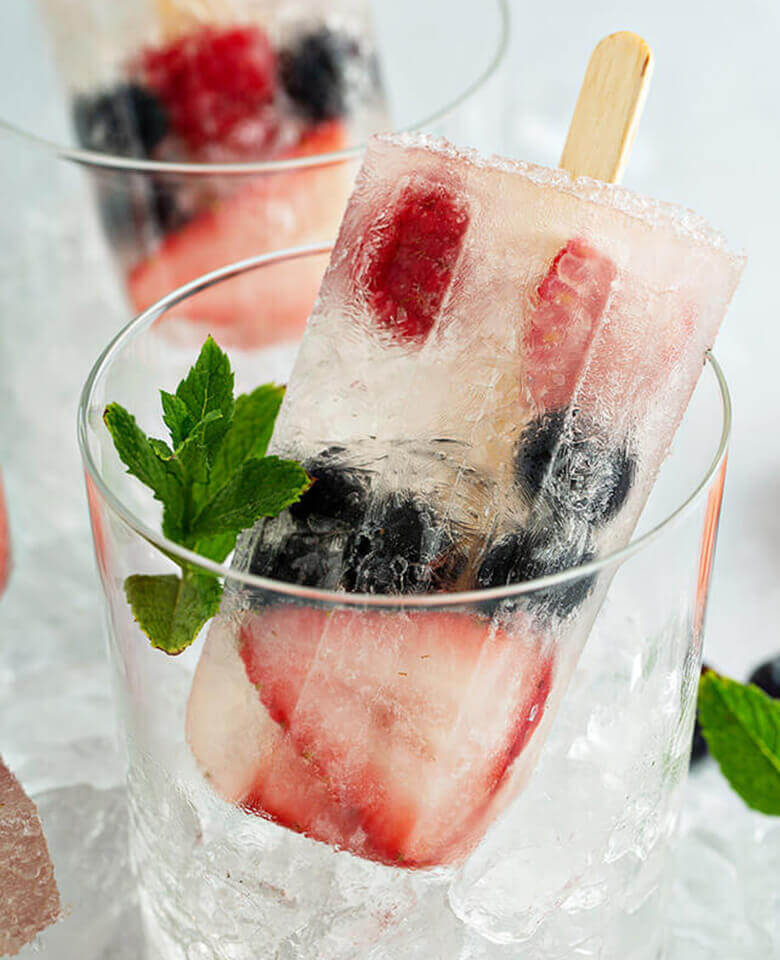 berry filled popsicles in cups on ice