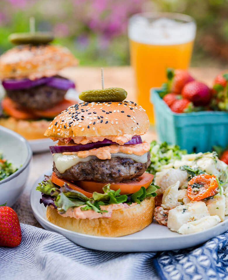 a tasty burger with pimento cheese on a summery table.