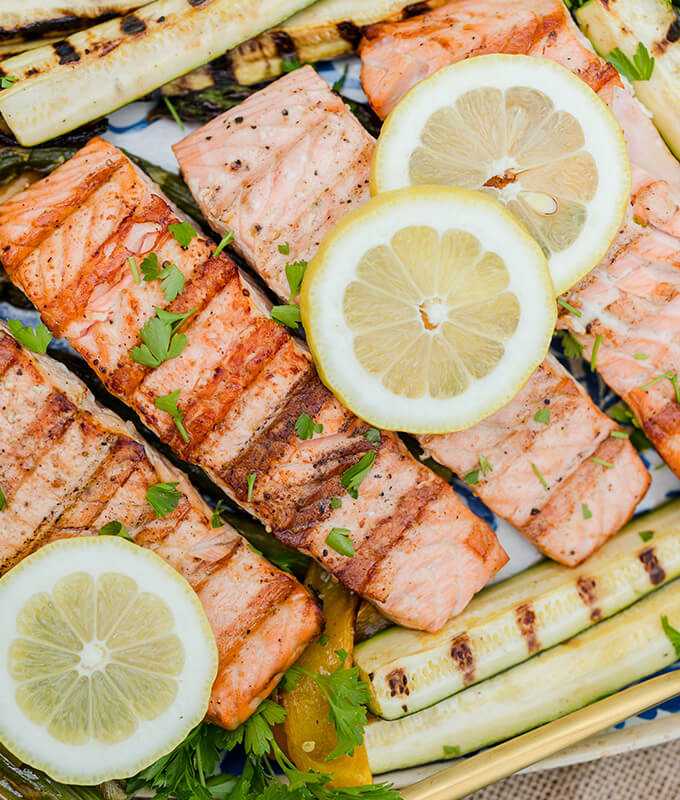 salmon filets with lemon and vegetables on the grill