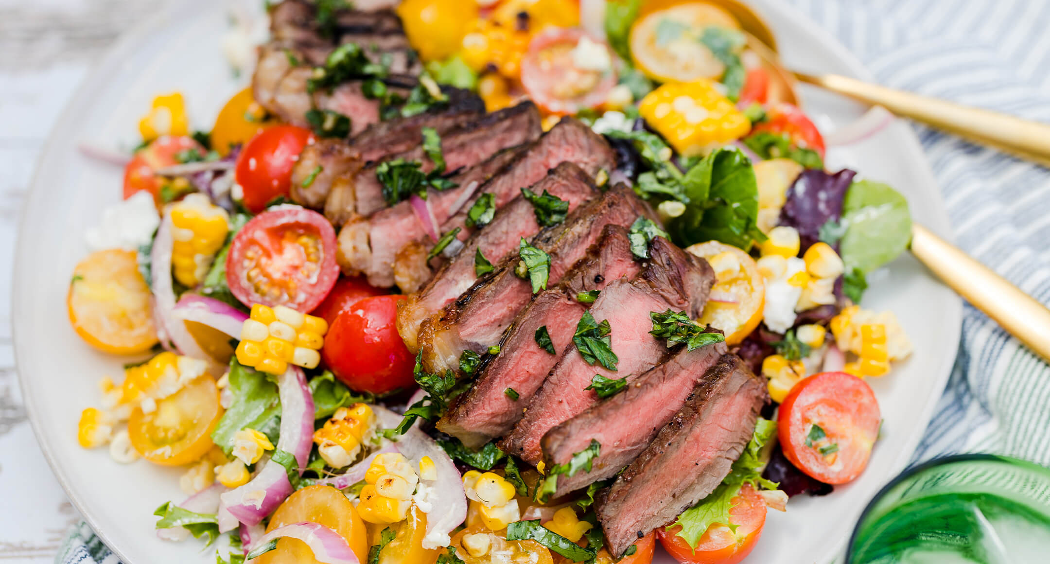 Grilled New York steak sliced and served atop a fresh corn and tomato salad. 