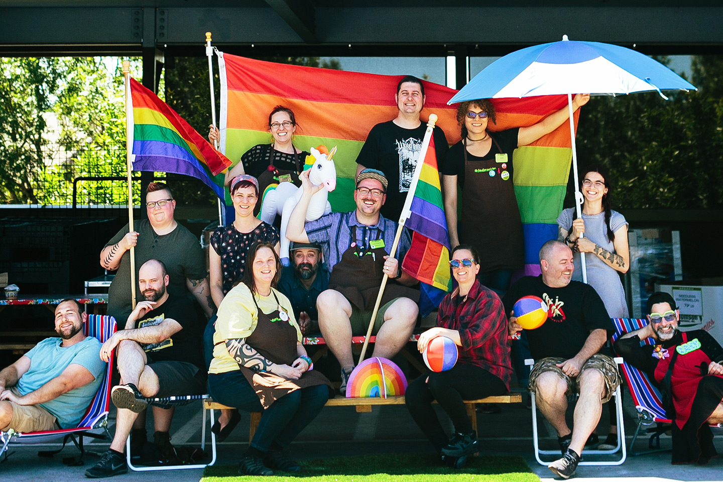 New Seasons staff members in front of a pride flag