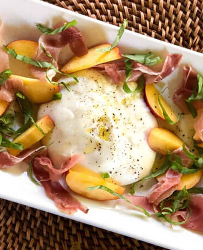 burrata surrounded by slices of fresh peaches