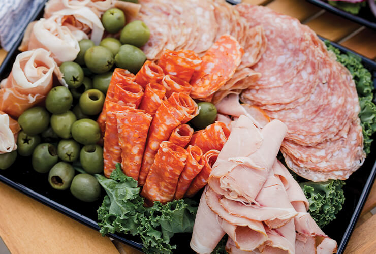 A tray of deli meat and olives