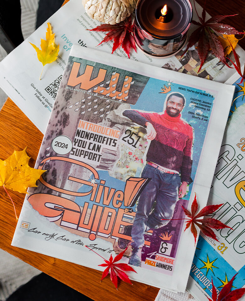 The Willamette Week Give Guide on a table arranged with leaves and a candle