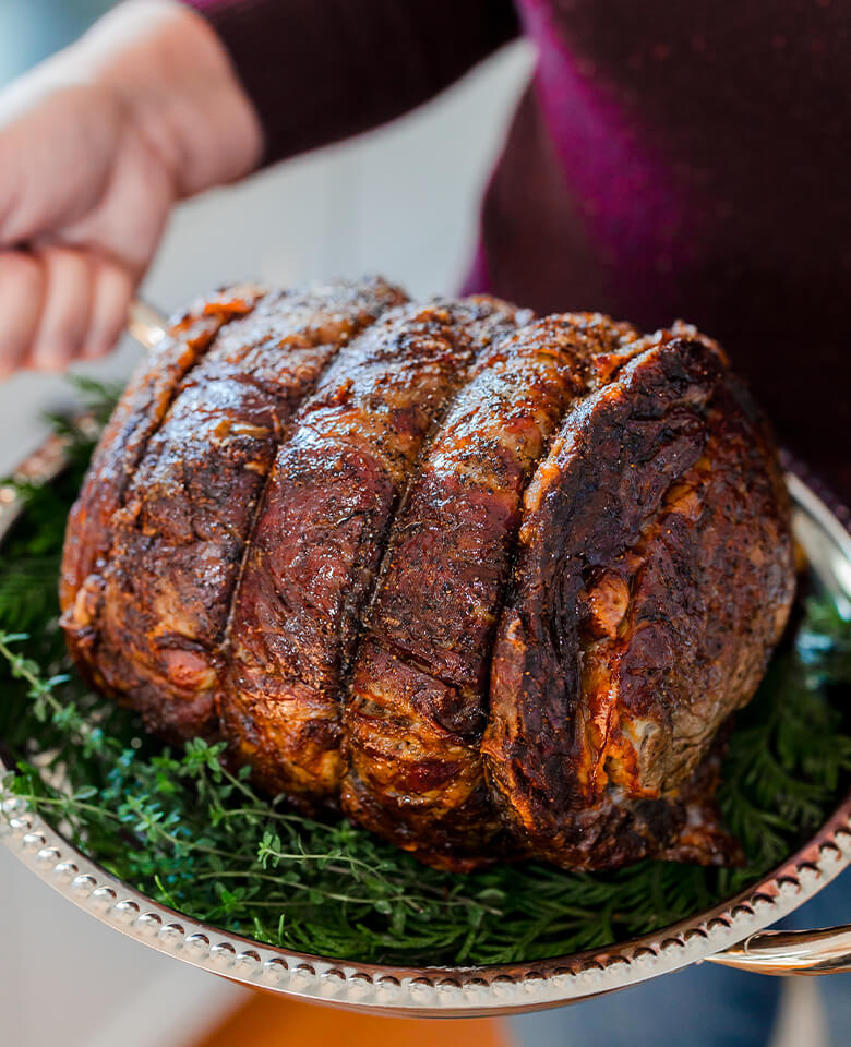 A close-up image of a roasted prime rib roast on a serving platter.