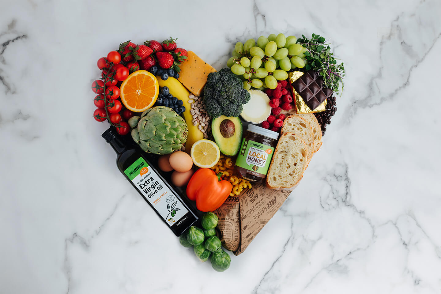 Food arranged in the shape of a heart on a marble backdrop