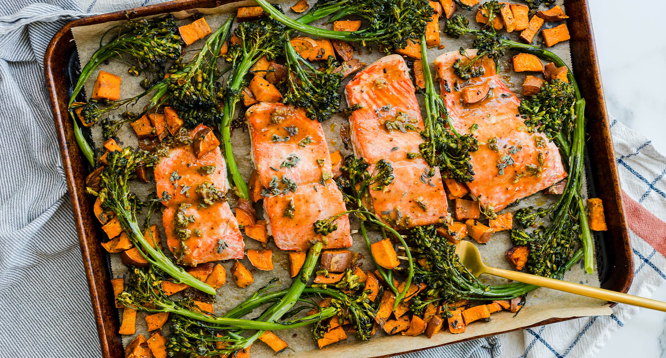 Baked salmon on a sheet-pan with roasted broccolini and cubed squash. 