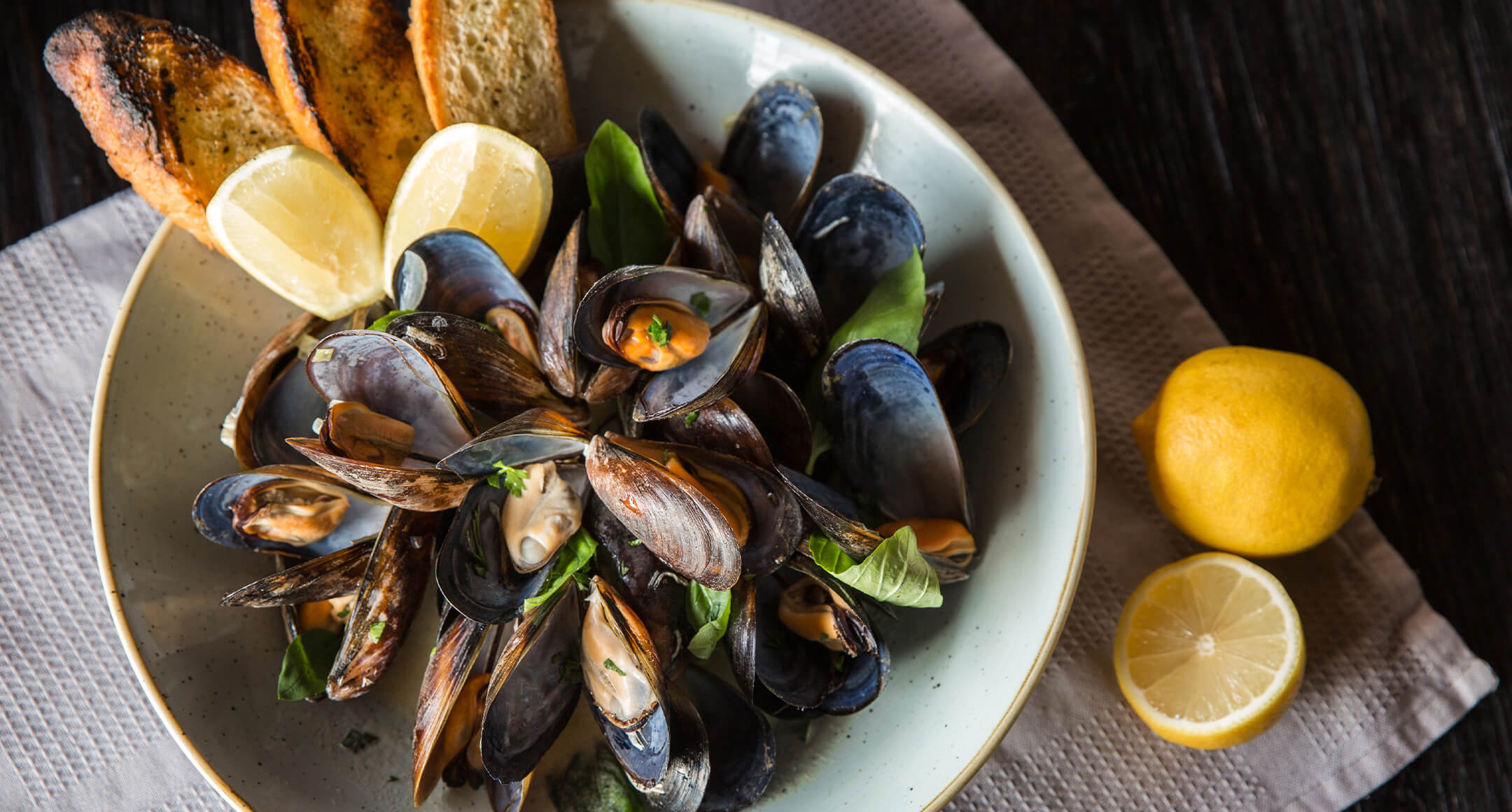 A bowl filled with steamed mussels. 